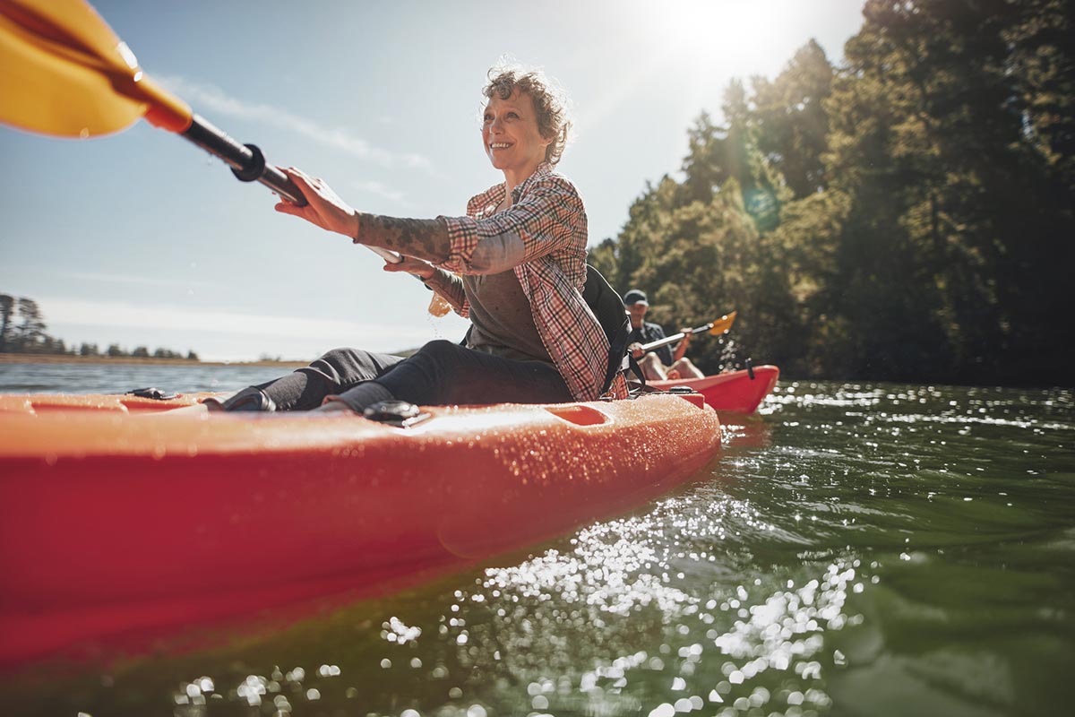 Woman paddling a kayak.